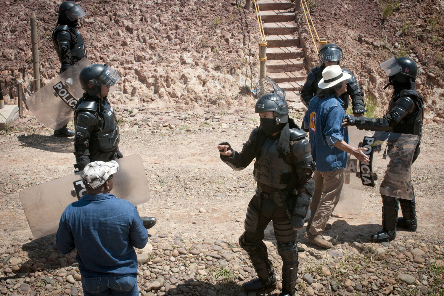 4 octobre 2012. Deux syndicalistes essayent d’entrer dans un campement de travailleurs en grève que la police anti-émeute vient illégalement d’envahir. La médiation des syndicalistes permet finalement le retrait des policiers et le retour des travailleurs dans le camp. Cette photo a gagné en novembre 2013 le prix Allard Photo Competition dédiés au thème des droits de l’Homme et de la lutte anti-corruption.