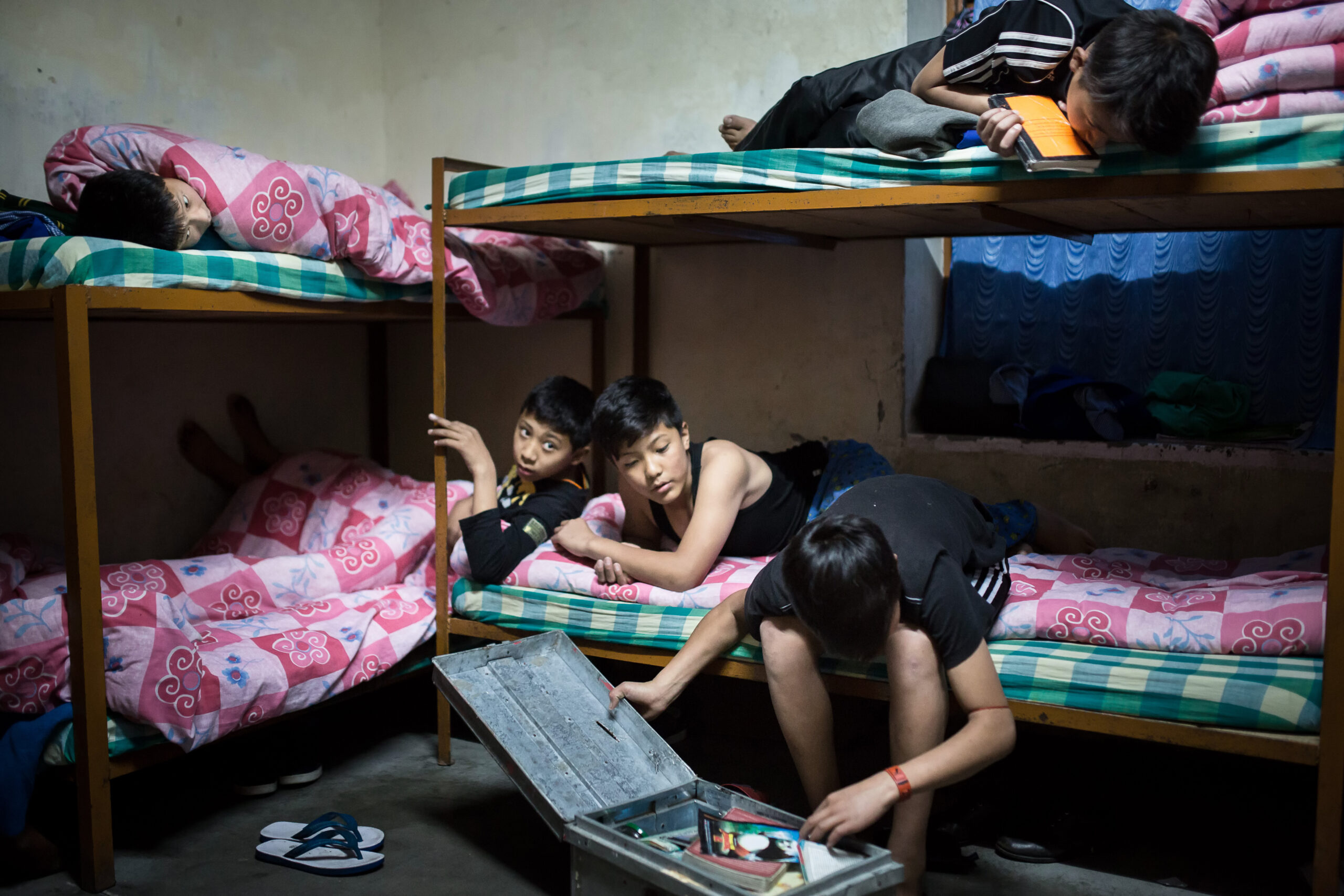 Dans le dortoir des garçons, juste avant de s'endormir, l'un d'entre eux ouvre son coffre, dans lequel il garde tous ses souvenirs. Le Tibetan Children's Village à Dharamsala, en Inde, accueille les enfants tibétains qui ont fui l'occupation chinoise.   //   In the boys dorm, just before sleeping, one of the boys opens a chest in which he keeps all the memories of his family. The Tibetan Children's Village, in Dharamsala (India), welcomes tibetan children who ran away from the chinese occupation.